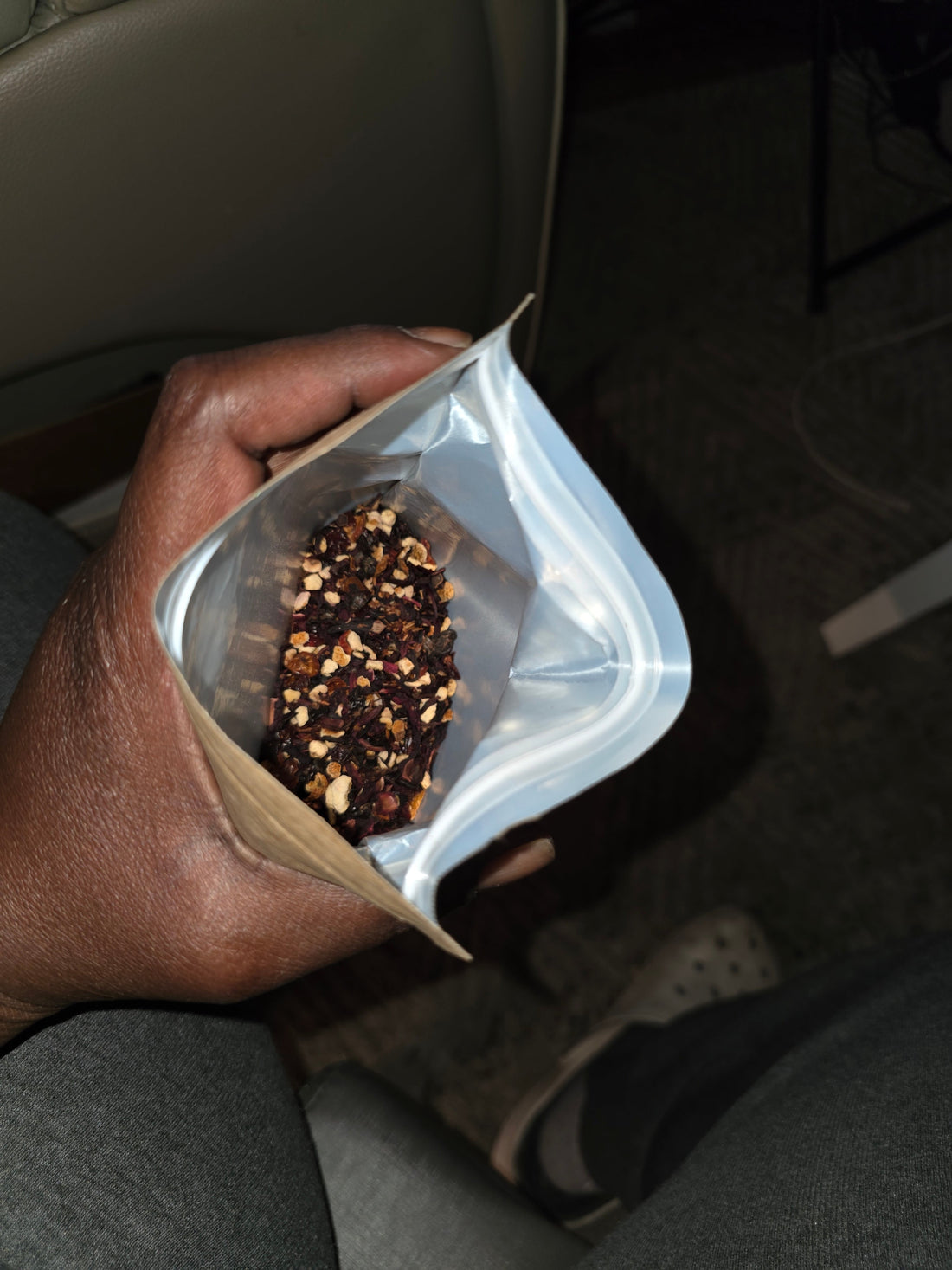 ​A brown kraft paper stand-up pouch of "The Tidal Basin Bloom" loose leaf tea resting on a gray marbled countertop. The label features soft pink cherry blossom illustrations and a clean ingredient list.